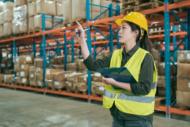 woman in warehouse checking inventory of goods - Photo, Image