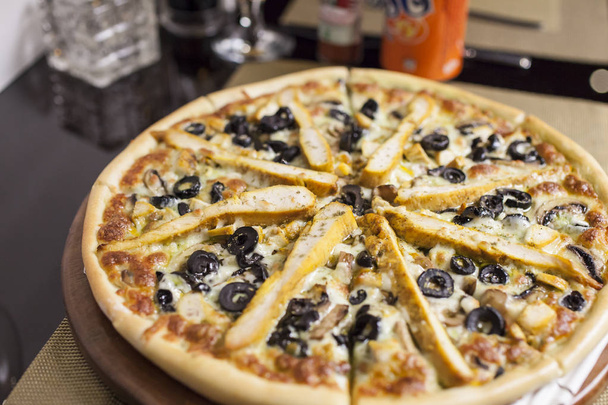 Uma pizza de frango italiana com azeitonas
 - Foto, Imagem