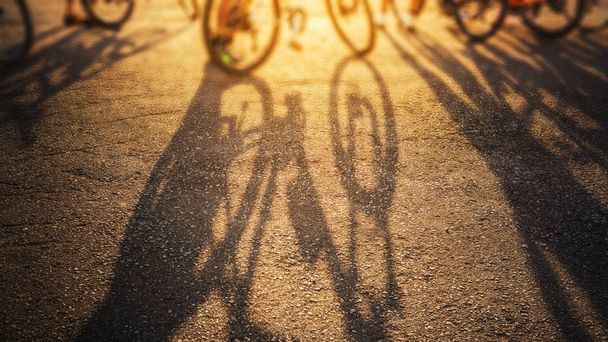 cień roweru na tle drogi powierzchniowej rano z lekkim świeci wschód słońca - Zdjęcie, obraz