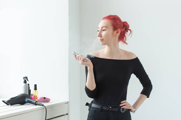 Vape, vício e conceito de pessoas - jovem mulher com cabelo colorido está fumando um vape
 - Foto, Imagem