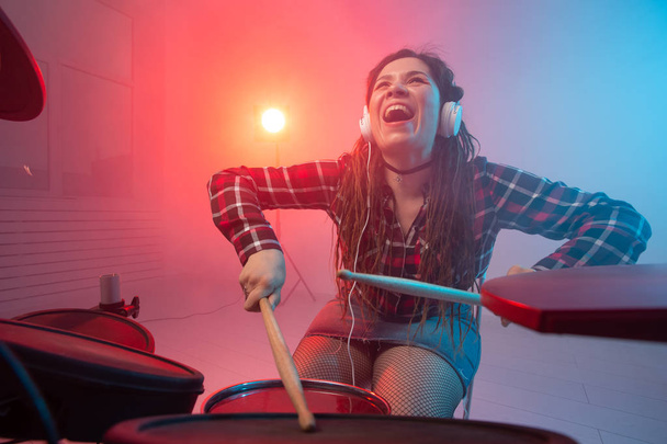 Hobby, music and people concept - Excited woman playing the electronic drum set - Photo, Image