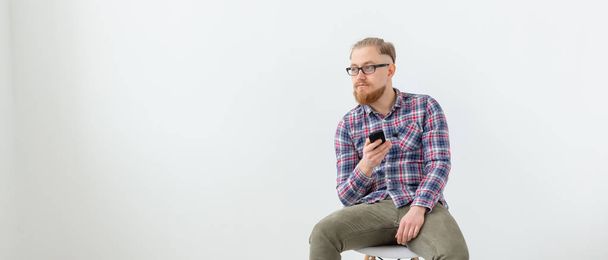 Mladý alternativců vousatý muž sedící na bílém pozadí s prostorem pro kopírování - Fotografie, Obrázek