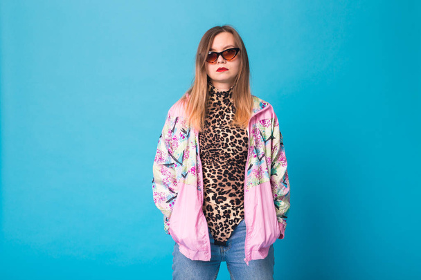 Vintage fashion look concept - pretty young woman wearing a retro pink jacket and leopard body on blue background with copy space - Zdjęcie, obraz