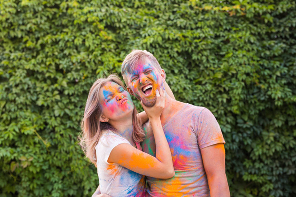 Holiday, holi and people concept - Happy couple having fun covered in paint - Zdjęcie, obraz