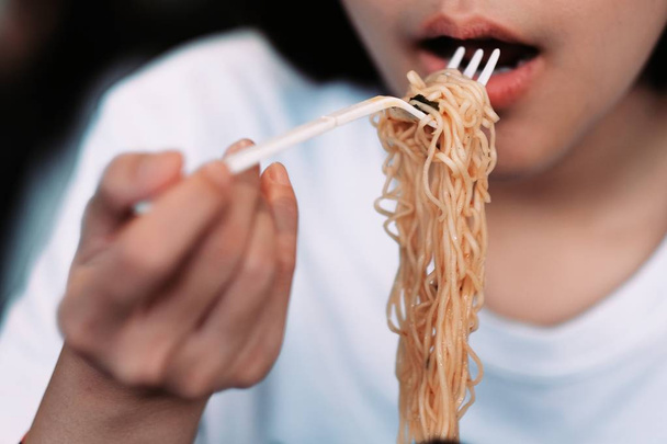 A girl eating spicy noodle cup - Foto, Imagem