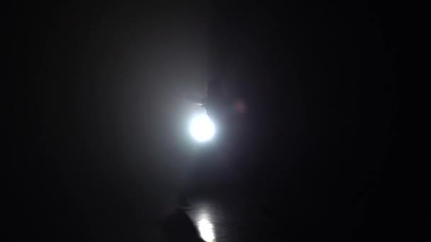 Мужчина практикует капоэйру в темноте против света. Медленное движение
. - Кадры, видео