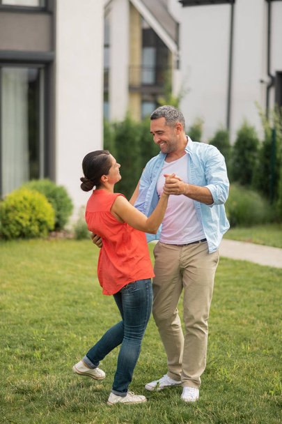 Husband dancing with wife and smiling while feeling happy - Photo, image
