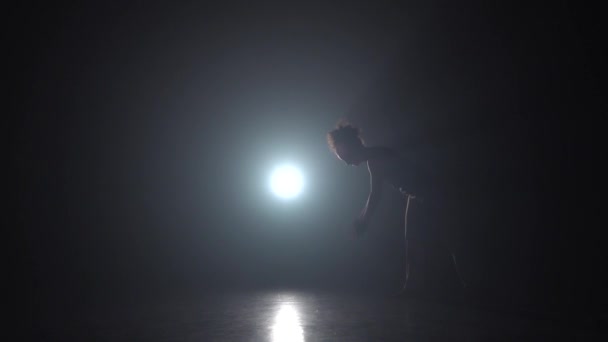 Capoeira. Woman in dark studio against light spotlight. Slow motion. - Footage, Video