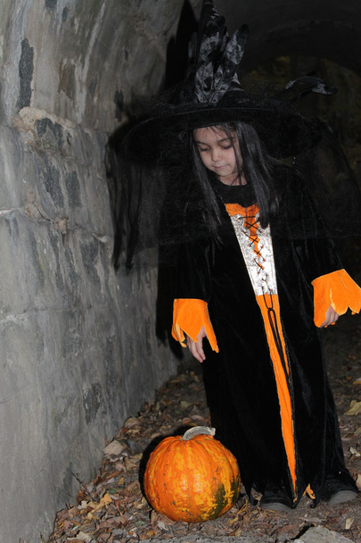 Witch child with a pumpkin in Halloween eve - Fotoğraf, Görsel