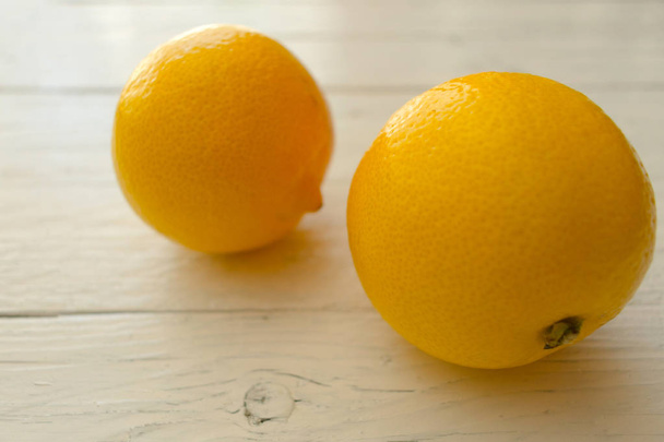  Two lemons on a white wooden table. Close-up - Foto, Imagem