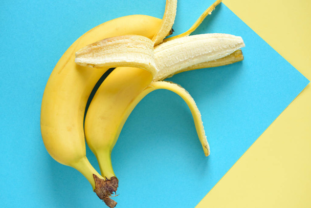 Two bananas on the turquoise-yellow background - Photo, Image