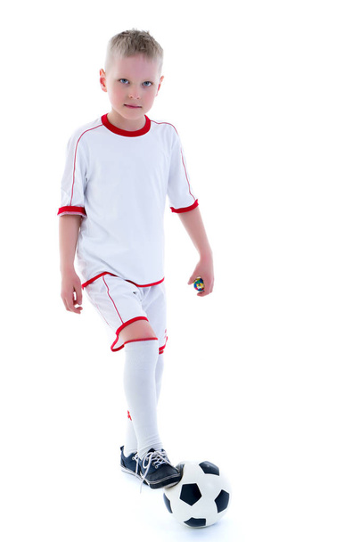 Saf beyaz giyen küçük bir çocuk t-shirt ile bir socc oynuyor - Fotoğraf, Görsel