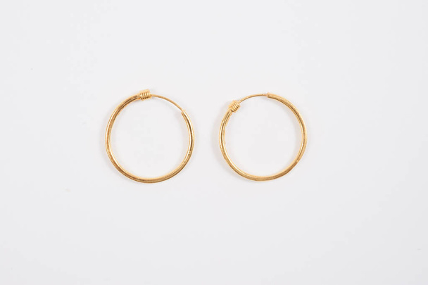  Loop gold earrings on the white background  - Photo, Image