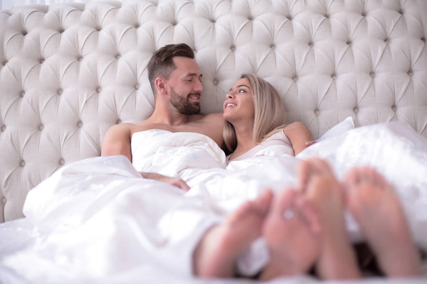 loving couple talking while lying on the bed - 写真・画像