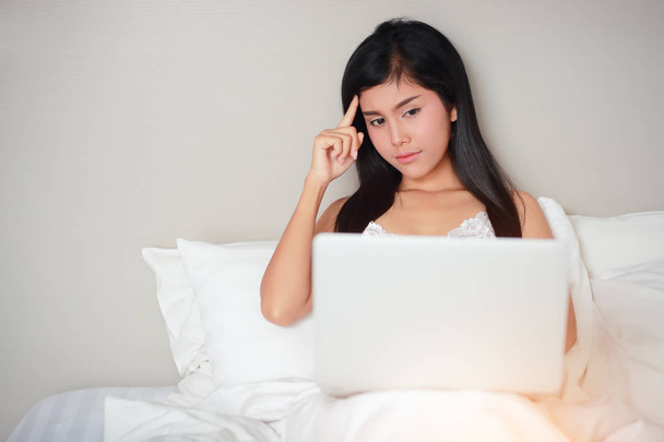 krásná a sexy žena, která používá přenosný počítač na posteli před spanem - Fotografie, Obrázek