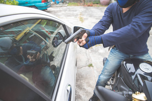 araba veya para çalmaya çalışırken motosiklet üzerinde silah ile hırsız (hırsızlık kavramı) - Fotoğraf, Görsel