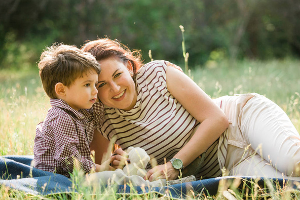 Madre feliz con lindo niño divirtiéndose al aire libre. Mujer alegre jugando con su hijo en el parque. Maternidad alegre
. - Foto, imagen