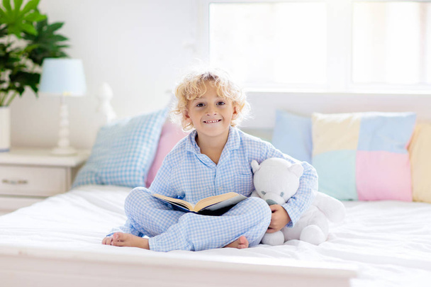 Kinderbuch im Bett. Kinder lesen im Schlafzimmer.  - Foto, Bild