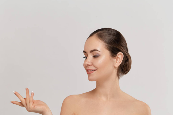 Woman surprise showing product .Beautiful girl expressive pointing to the side. Presenting your advertisement. Expressive facial expressions - 写真・画像