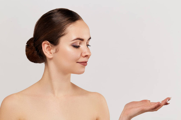 Woman surprise showing product .Beautiful girl expressive pointing to the side. Presenting your advertisement. Expressive facial expression - 写真・画像