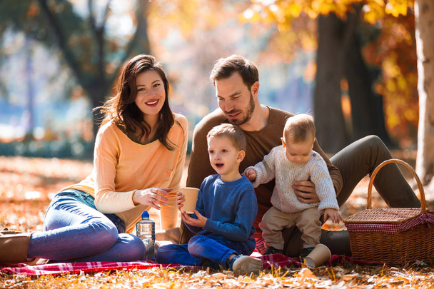 Щаслива сім'я з чотирьох розважається разом у парку восени
 - Фото, зображення