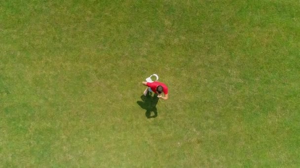 Luchtfoto van de mens, die een vr-headset in zijn hand neemt in het Park. Jonge kerel in helm ervaren Augmented Reality op de achtergrond van de natuur. 4k drone-opnames. - Video