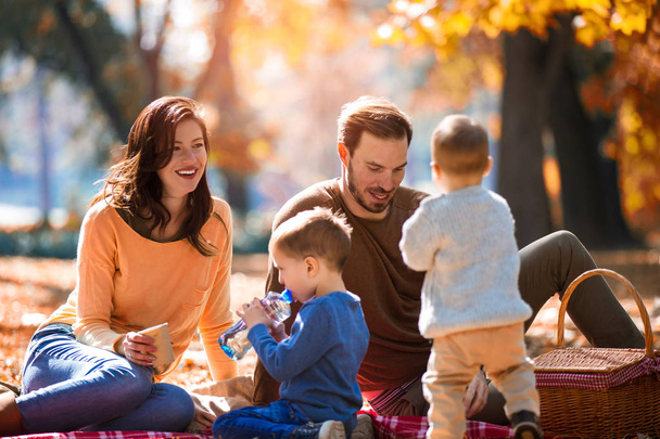 ευτυχισμένη οικογένεια τεσσάρων διασκεδάζοντας μαζί στο πάρκο φθινόπωρο - Φωτογραφία, εικόνα