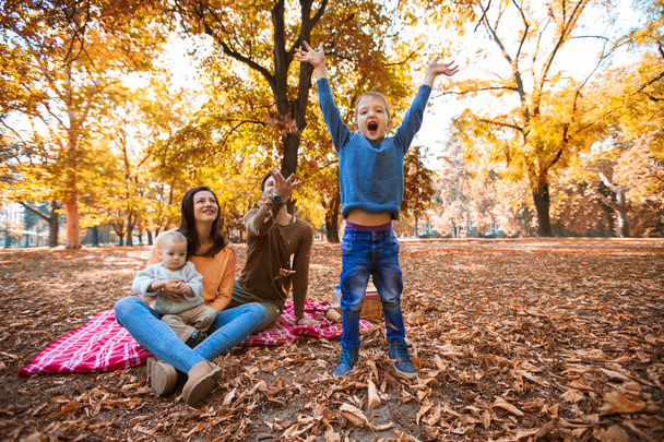 mutlu bir aile dört eğlenceli birlikte parkta sonbaharda sahip. - Fotoğraf, Görsel