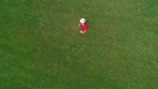 Letecký pohled na člověka, který má na hlavě náhlavní soupravu a hraje virtuální hru v parku. Mladý muž v helmě, který prožívá realitu na pozadí přírody. 4k bzukot záběr. - Záběry, video