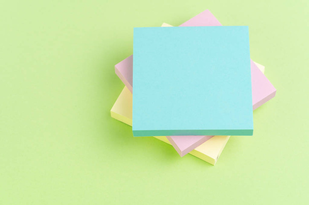 Stack of sticky notes on green background with pink, yellow and  - Photo, Image