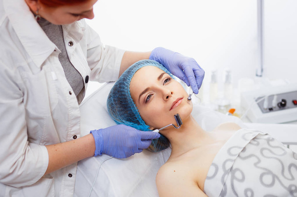 Zbliżenie młoda kobieta twarz podczas Microcurrent Therapy. - Zdjęcie, obraz
