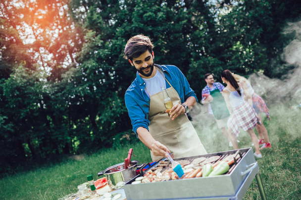 Beau mâle préparant barbecue en plein air pour les amis
 - Photo, image