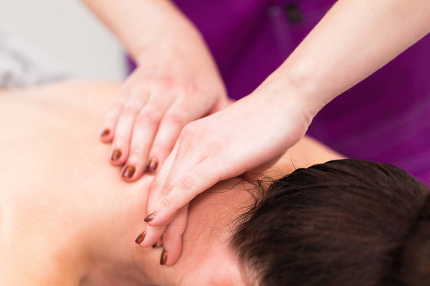 Beautiful brunette woman having a massage in a beauty salon - 写真・画像