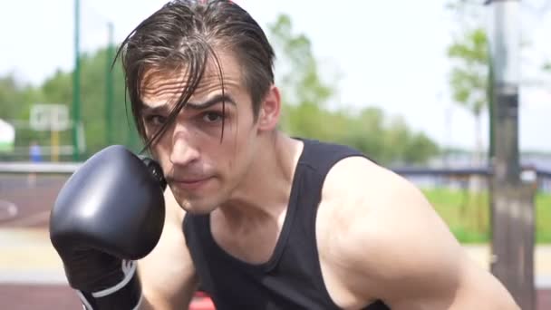 Movimento lento. jovem muscular homem boxer faz golpes na câmara, tiro constante
 - Filmagem, Vídeo
