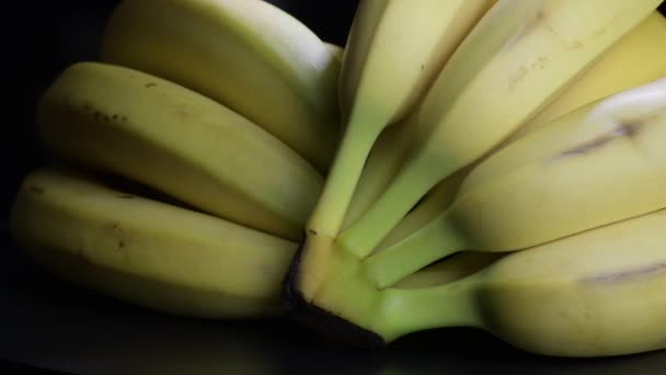 Manojos de plátanos girando sobre fondo negro
 - Imágenes, Vídeo