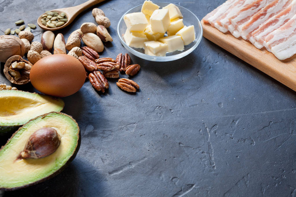 Ketogenic diet food: avocado, nuts, cream, oil, bacon, closeup - Foto, afbeelding