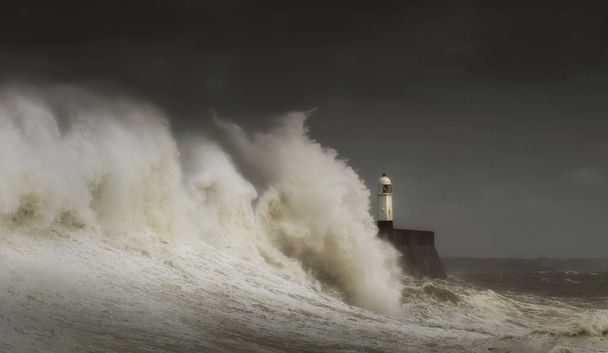 Porthcawl deniz feneri ve Güney Galler kıyısında bir fırtınanın çenesinde iskele, İngiltere. - Fotoğraf, Görsel