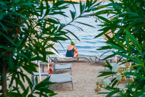 Peeping over een meisje op het strand van achter struiken - Foto, afbeelding