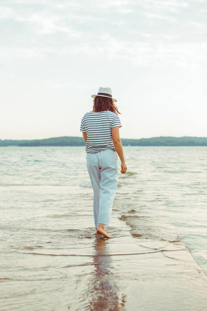 γυναίκα με λευκά ρούχα περπάτημα από τη θάλασσα παραλία - Φωτογραφία, εικόνα