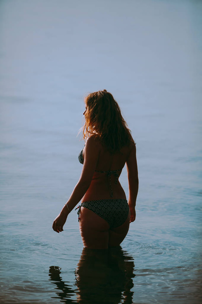 Kobieta w strój kąpielowy przed morzem nie ma twarzy - Zdjęcie, obraz