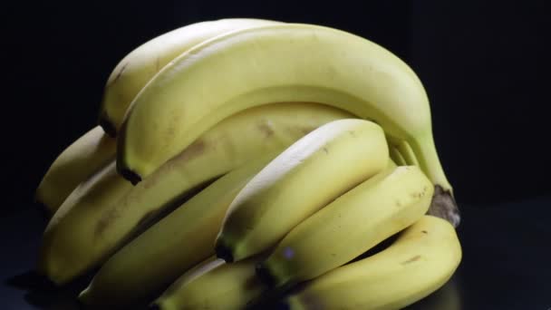 Fresco banane grappolo girando su sfondo nero
 - Filmati, video