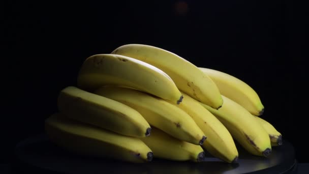 Banán csokor gyrating fekete háttér - Felvétel, videó