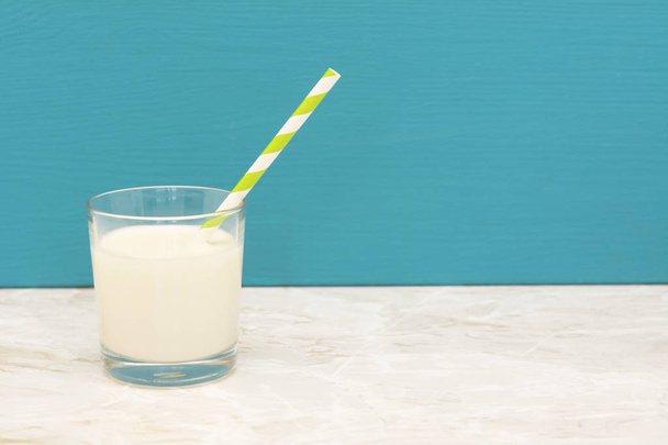 Creamy, fresh milk with a straw in a glass - Photo, image