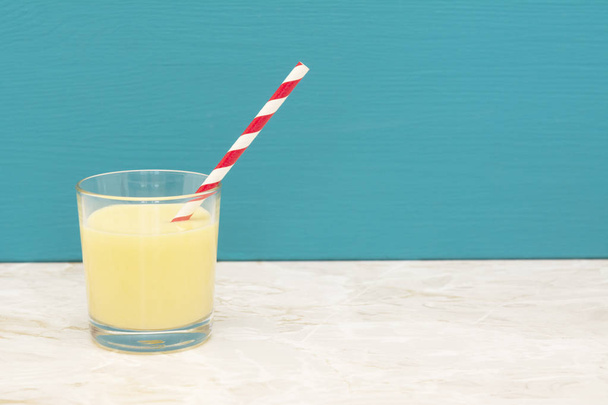 Tasty banana milkshake with a straw in a glass  - Foto, imagen