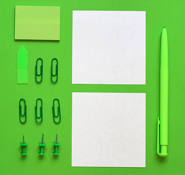 Στυλό, χαρτί και επιστολόχαρτα σε πράσινο φόντο. Στο πράσινο στυλ. Η έννοια της αειφόρου επιχειρηματικής δραστηριότητας. Επίπεδη όψη, κορυφή. Θέση για κείμενο - Φωτογραφία, εικόνα