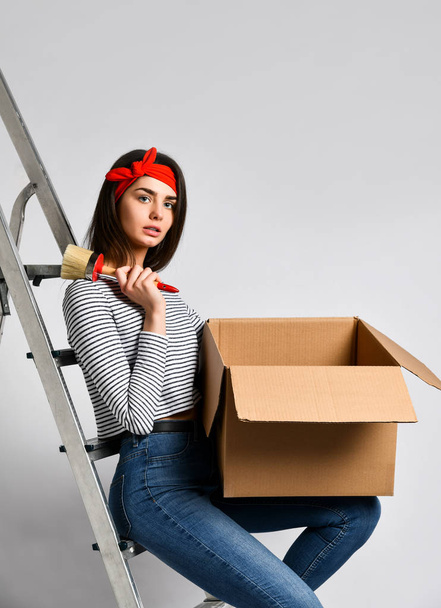 Smiling young woman holding cardboard box isolated on white background - Φωτογραφία, εικόνα