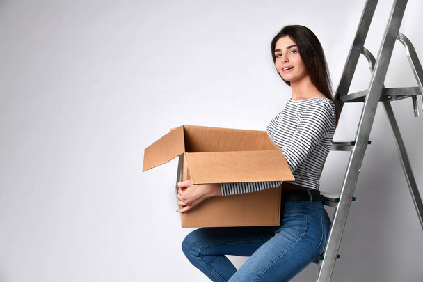 Smiling young woman holding cardboard box isolated on white background - Φωτογραφία, εικόνα