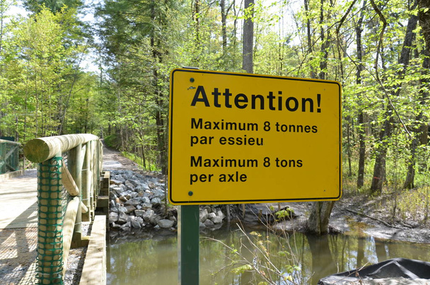 atenção amarela máximo 8 toneladas por sinal de eixo em francês e inglês na ponte
 - Foto, Imagem