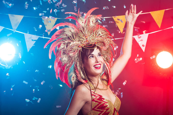 Carnaval, bailarina y concepto de vacaciones - Mujer morena de belleza en traje de cabaret y tocado con plumas naturales y pedrería
. - Foto, Imagen