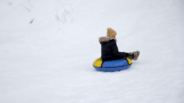 Giovane donna sta scivolando dalla collina di neve a tubi al rallentatore
. - Filmati, video